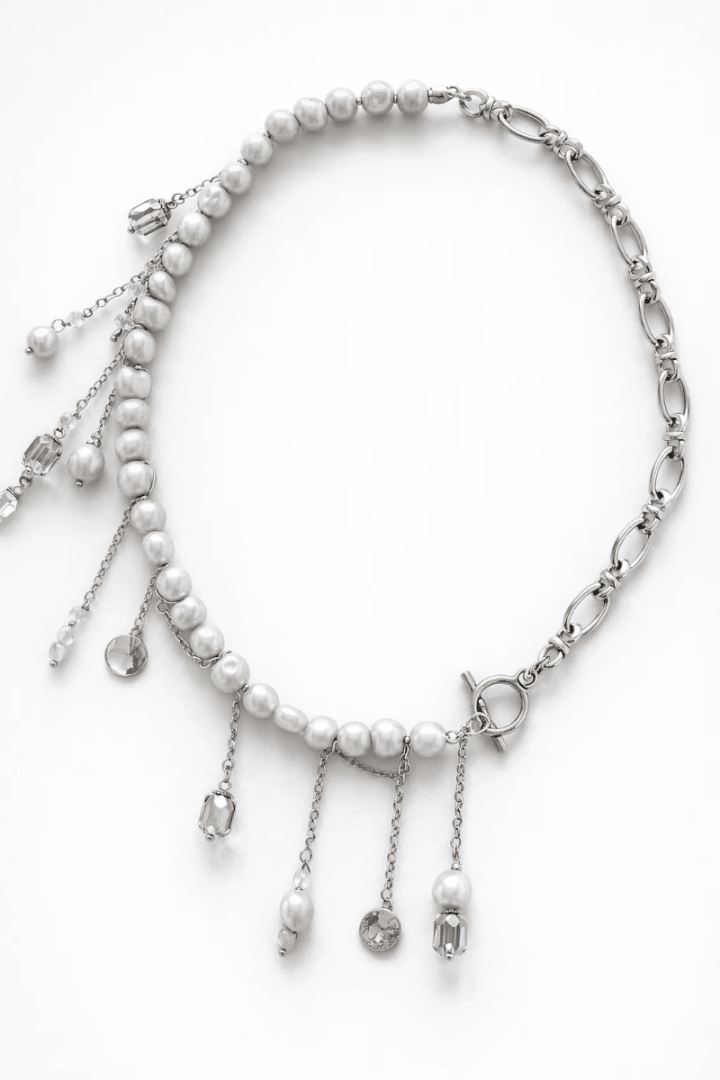 Чокер із сірих перлин та ланцюжків з багатьма підвісками.