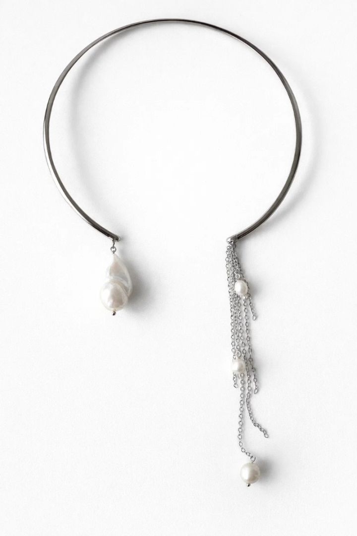 Чокер жорсткий, має 2 асиметричні кінця з перлин.